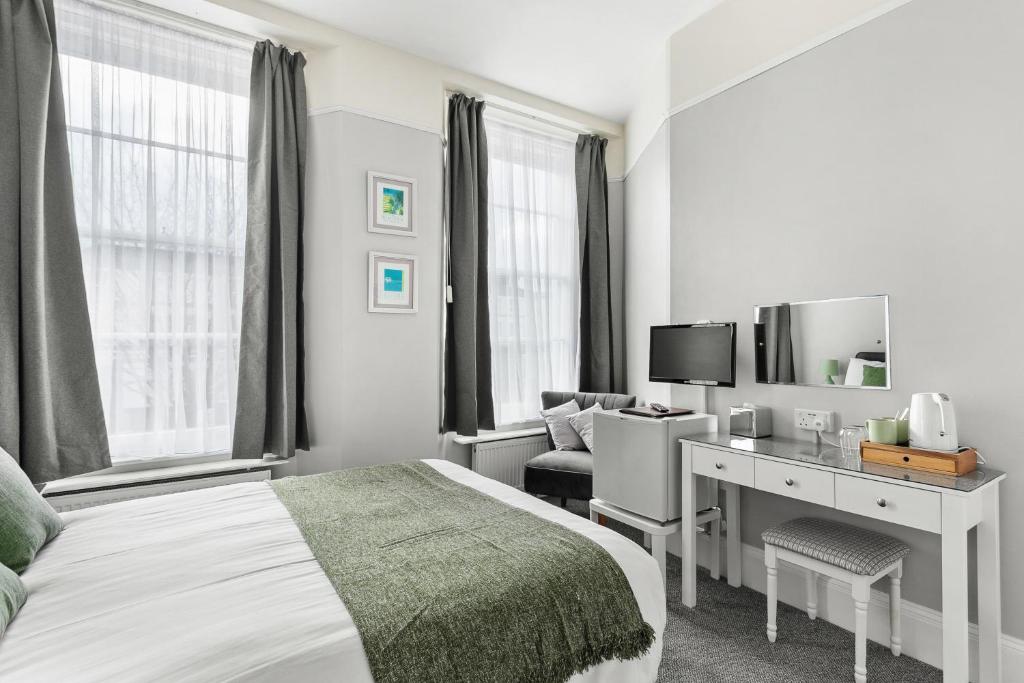 a bedroom with a bed and a desk and a tv at South view in Torquay