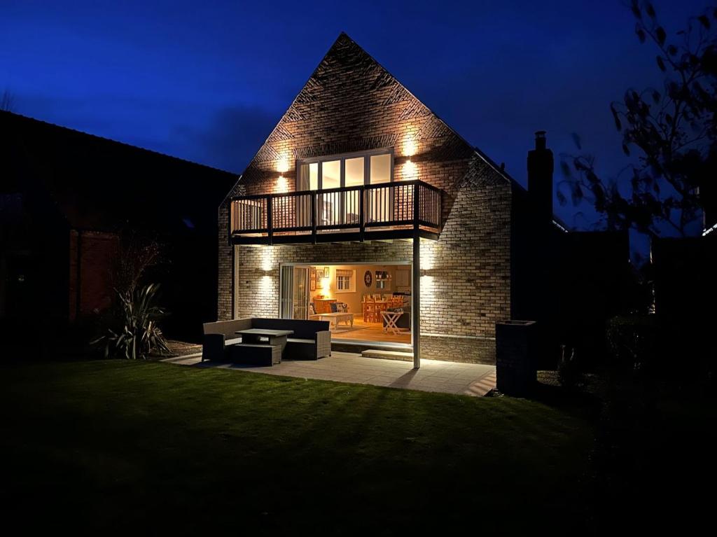 a house with a balcony and a patio at night at Ocean Retreat in Filey