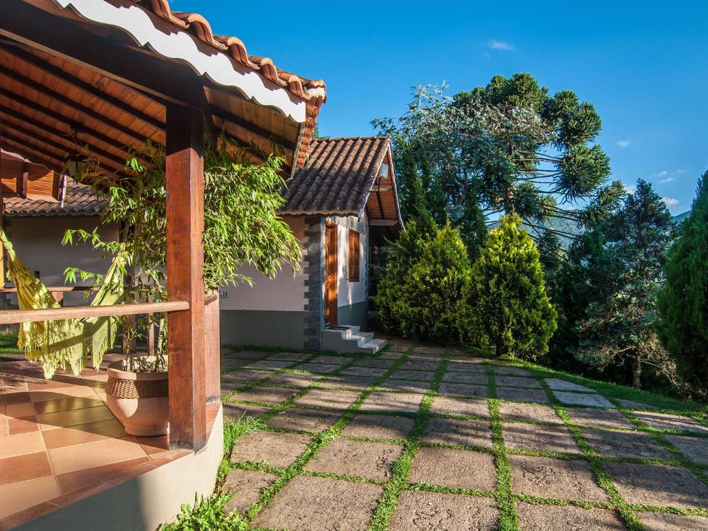 a house with a garden and a fence at Pousada Ricanto Amore Mio in Monte Verde