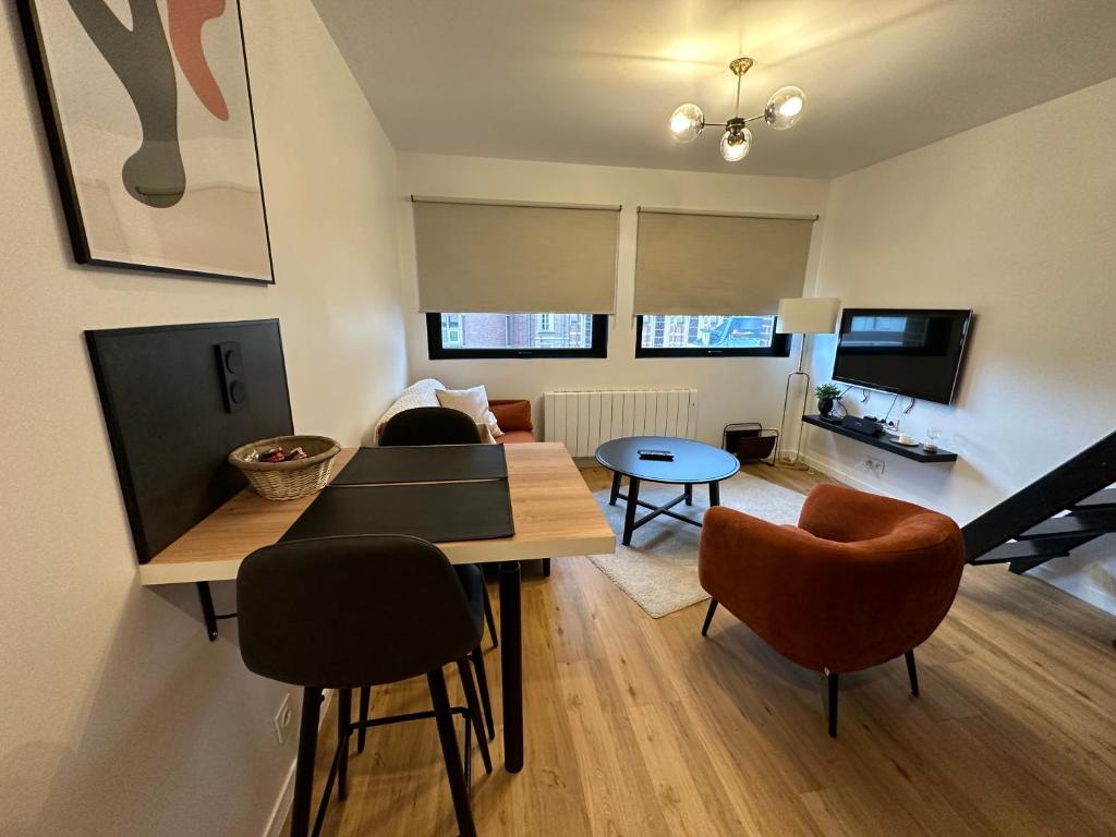 un salon avec une table et des chaises de salle à manger dans l'établissement Appartement moderne - 1 chambre, à Amiens