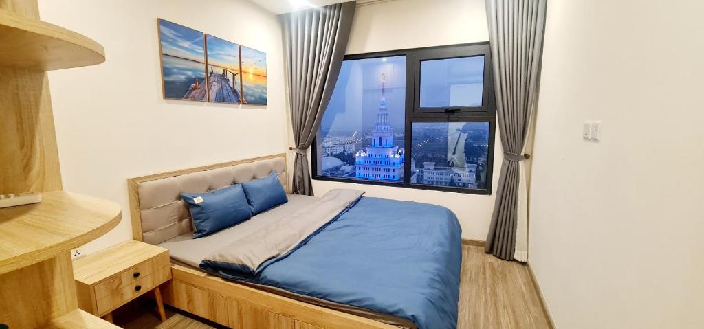een slaapkamer met een bed met blauwe lakens en een raam bij NK#Homestay#Vinhomes#Oceanpark#1PN#C26 in Gia Lâm Pho