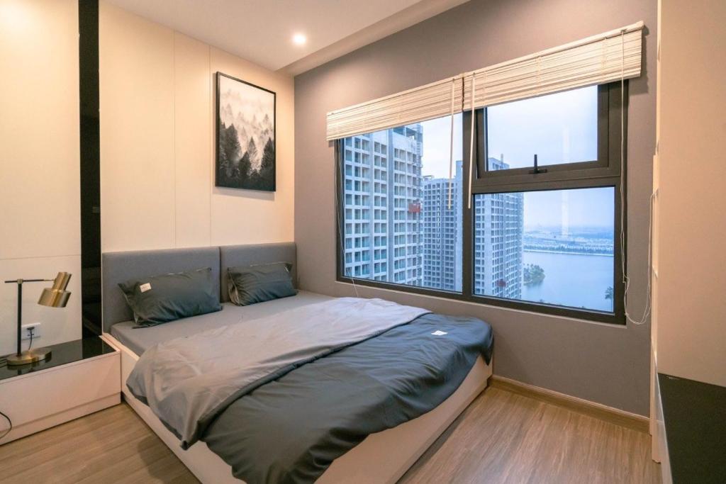 ein Schlafzimmer mit einem Bett und einem großen Fenster in der Unterkunft NK#Homestay#Vinhomes#Oceanpark#2PN#C29 in Gia Lâm Pho