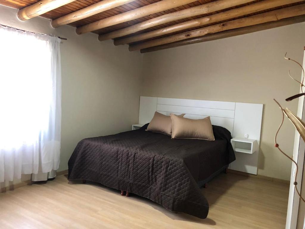 - une chambre avec un lit et une couette noire dans l'établissement Apartamentos María, à San Rafael