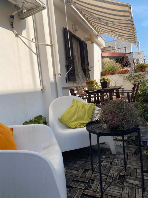 eine Terrasse mit einem weißen Sofa und einem Tisch in der Unterkunft Apulia Mola in Mola di Bari