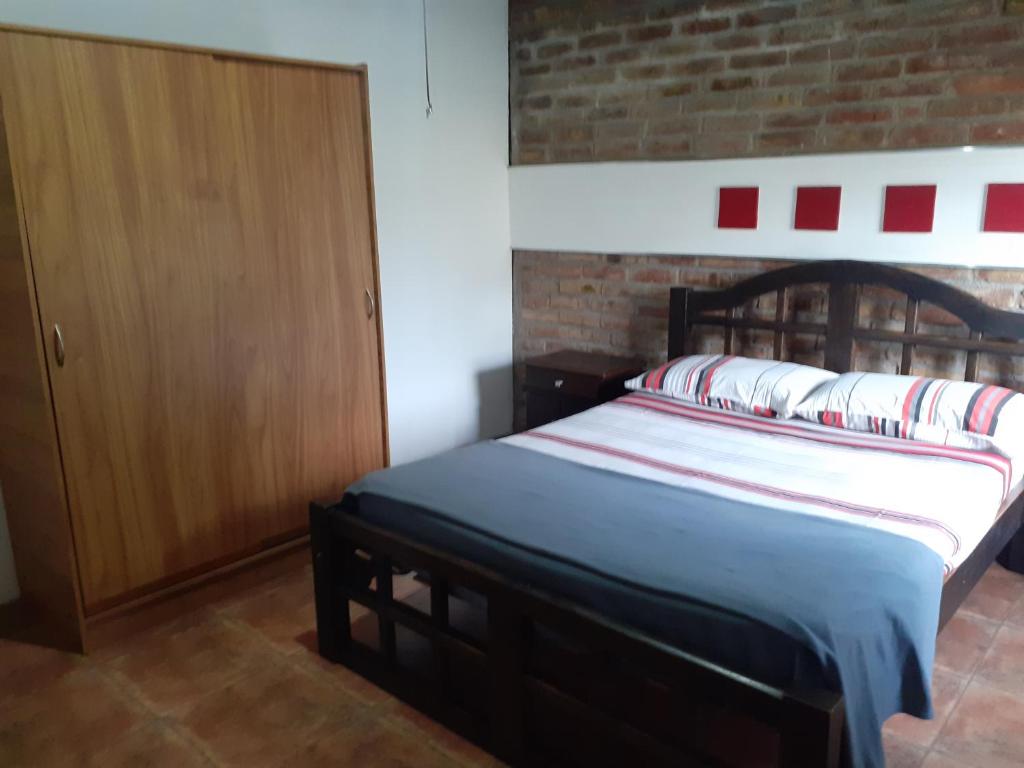 1 dormitorio con 1 cama y armario de madera en RUKAFUCHA en Mendoza