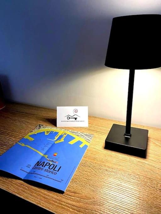 a desk with a lamp and a sign on a table at Pontecorvo Naples Apartament in Naples