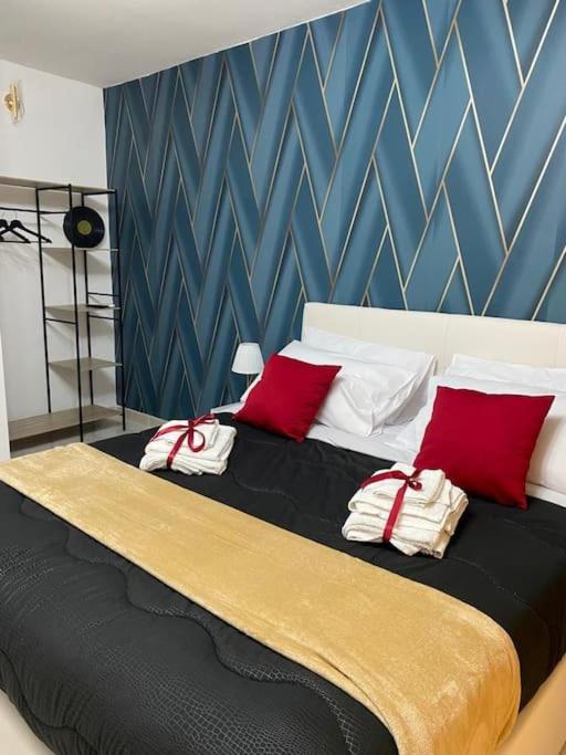 a bedroom with a large bed with red pillows at Pontecorvo Naples Apartament in Naples