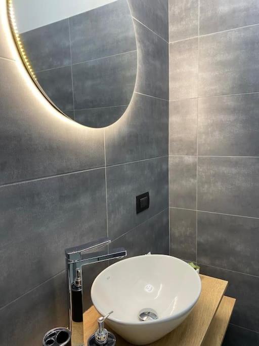a bathroom with a sink and a round mirror at Pontecorvo Naples Apartament in Naples