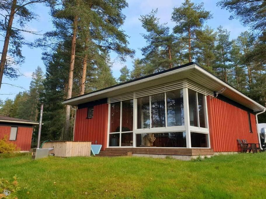 a red house with a large window at Kraatterimökki in Lappajärvi