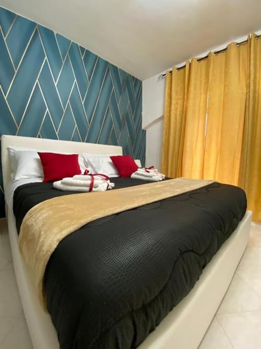 a bedroom with a large bed with red pillows at Pontecorvo Naples Apartament in Naples