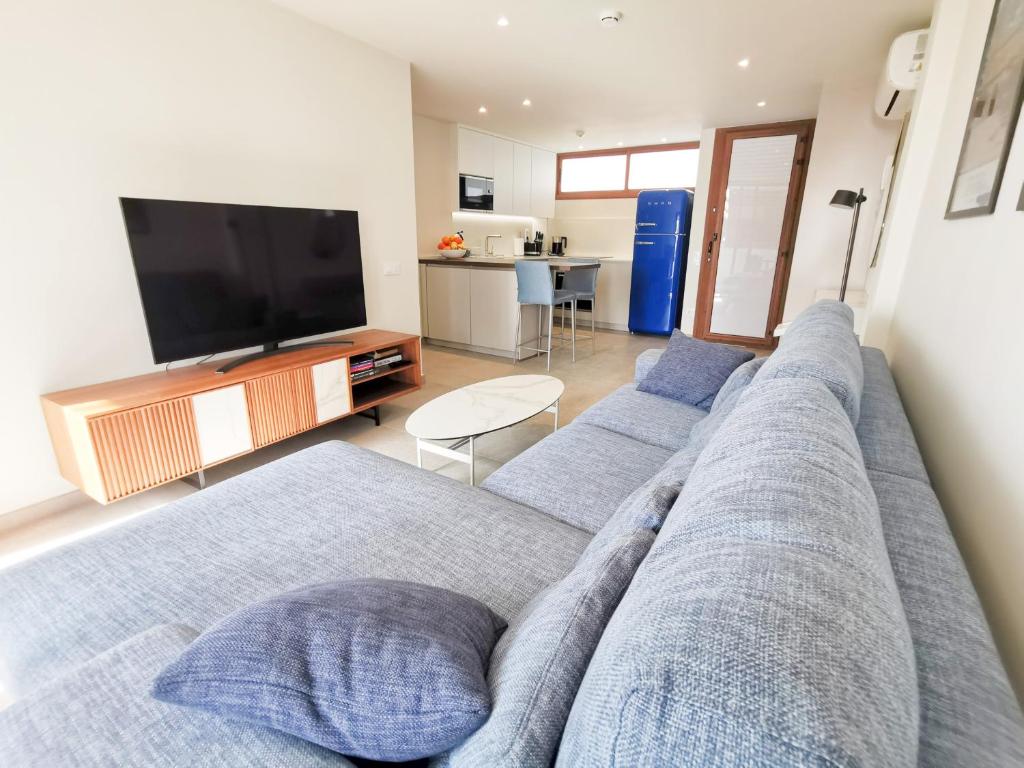 a living room with a couch and a flat screen tv at Cisne 32 in Playa del Ingles