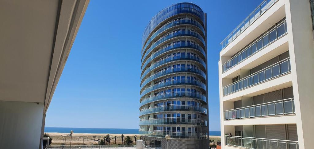 a tall building with the ocean in the background at Chez Ocean Plaza in Figueira da Foz