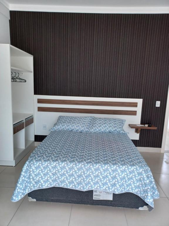 1 dormitorio con 1 cama con edredón azul en Loft Bombinhas Van Gogh en Bombinhas