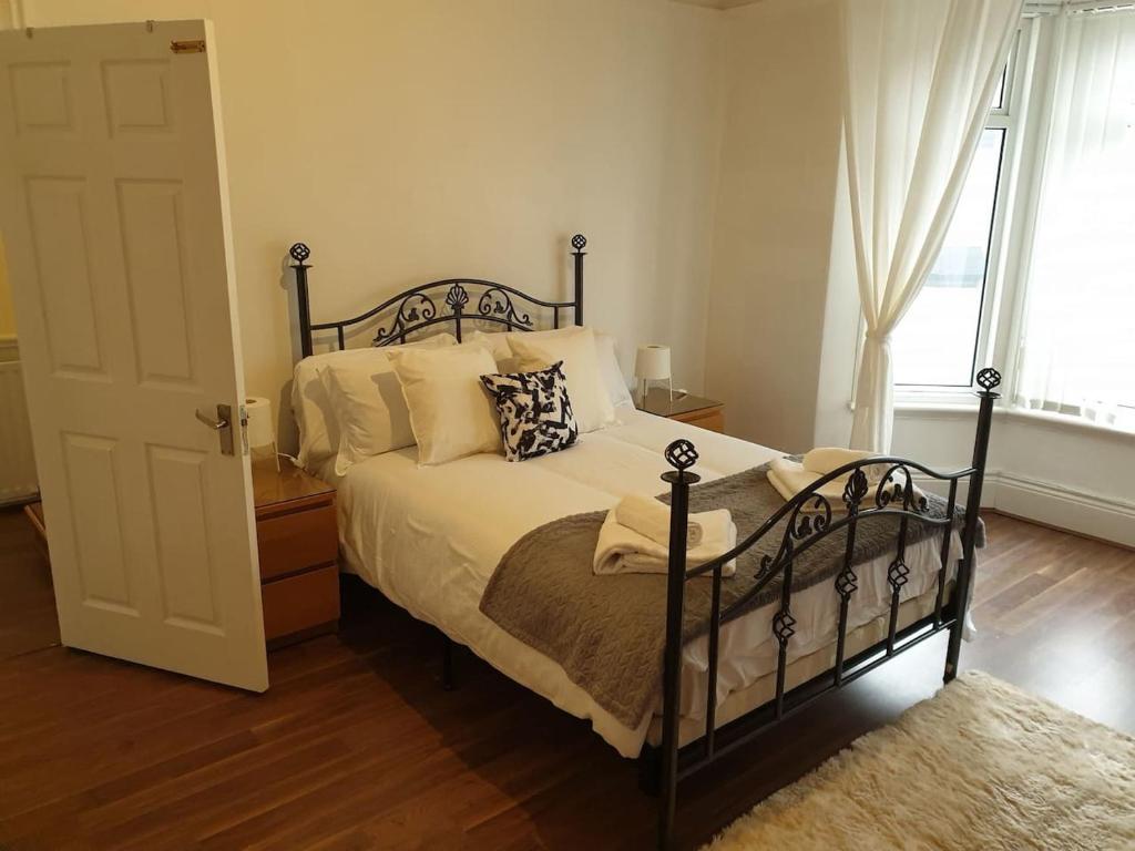 a bedroom with a bed and a door with a window at South Shield's Hidden Gem Garnet 3 Bedroom Apartme in South Shields