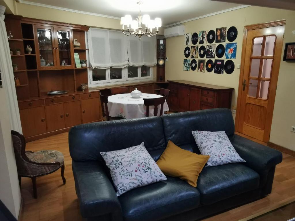 - un canapé en cuir noir dans un salon avec une table dans l'établissement Cómoda vivienda en Huesca, à Huesca