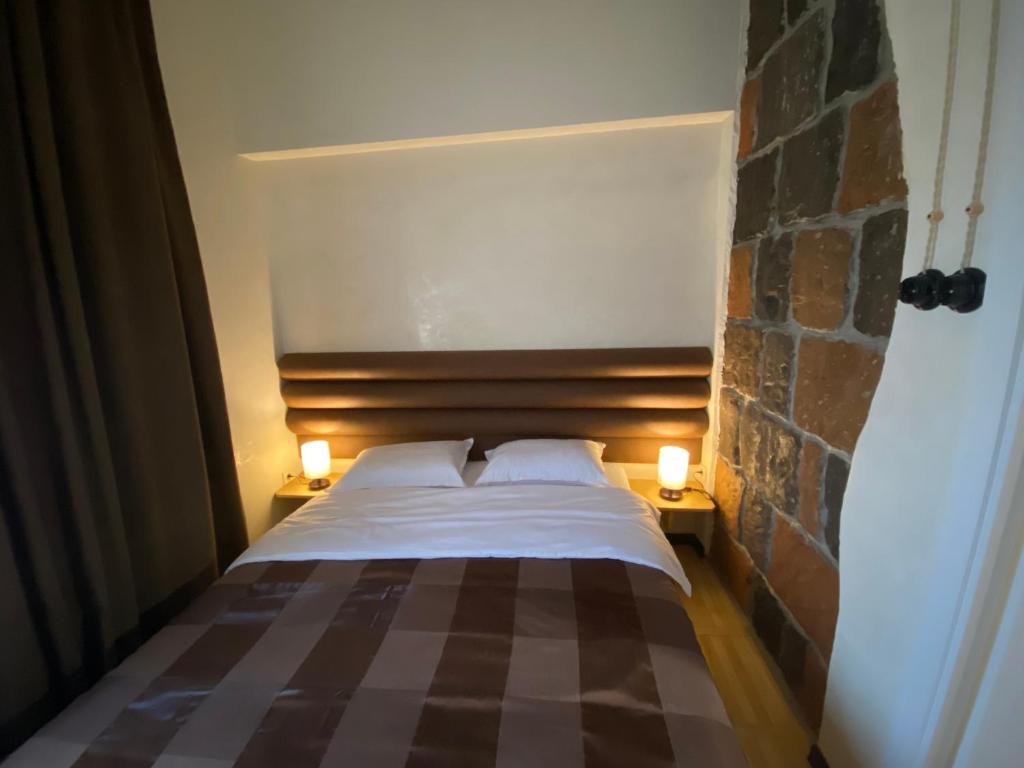 a bedroom with a bed with two lamps on the side at Apartments Pushkin Street in Yerevan