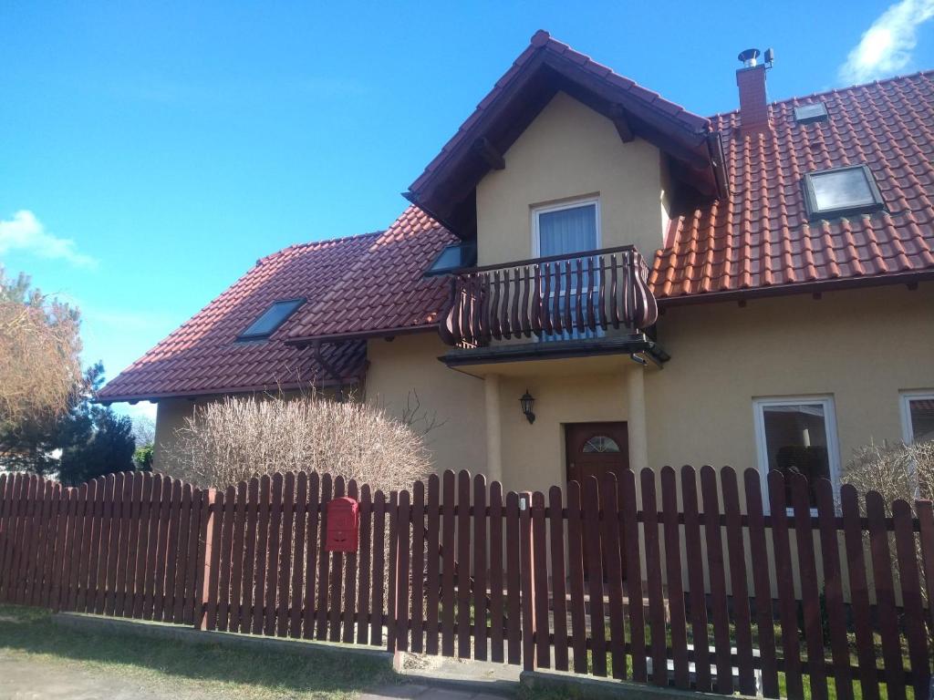 Casa con valla de madera y balcón en DIONIZY, en Kosakowo