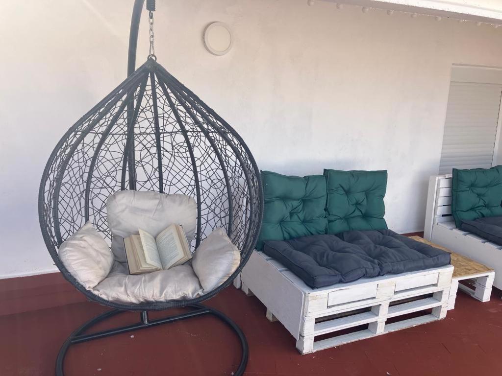 Casa Rural Eric في Les Coves de Vinroma: كرسي أرجوحة وأريكة في الغرفة