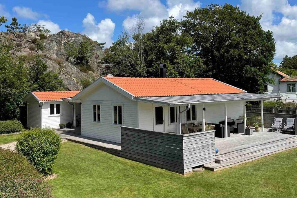 una pequeña casa blanca con techo naranja en Trevligt hus i mysiga Mollösund Tången, en Mollösund