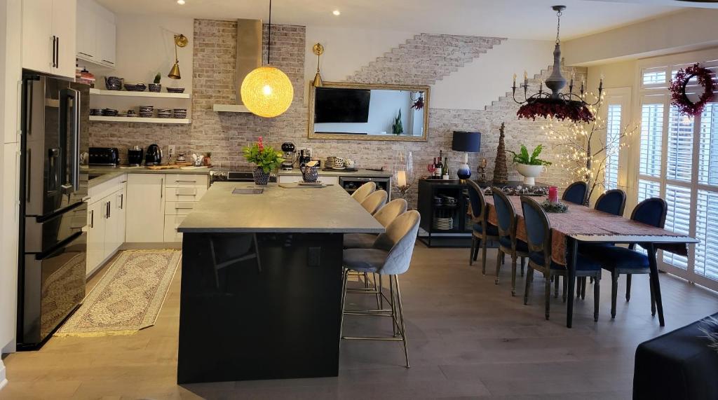 a kitchen with a large island with chairs and a table at Exclusive Townhome near West-Side Trails in Waterloo