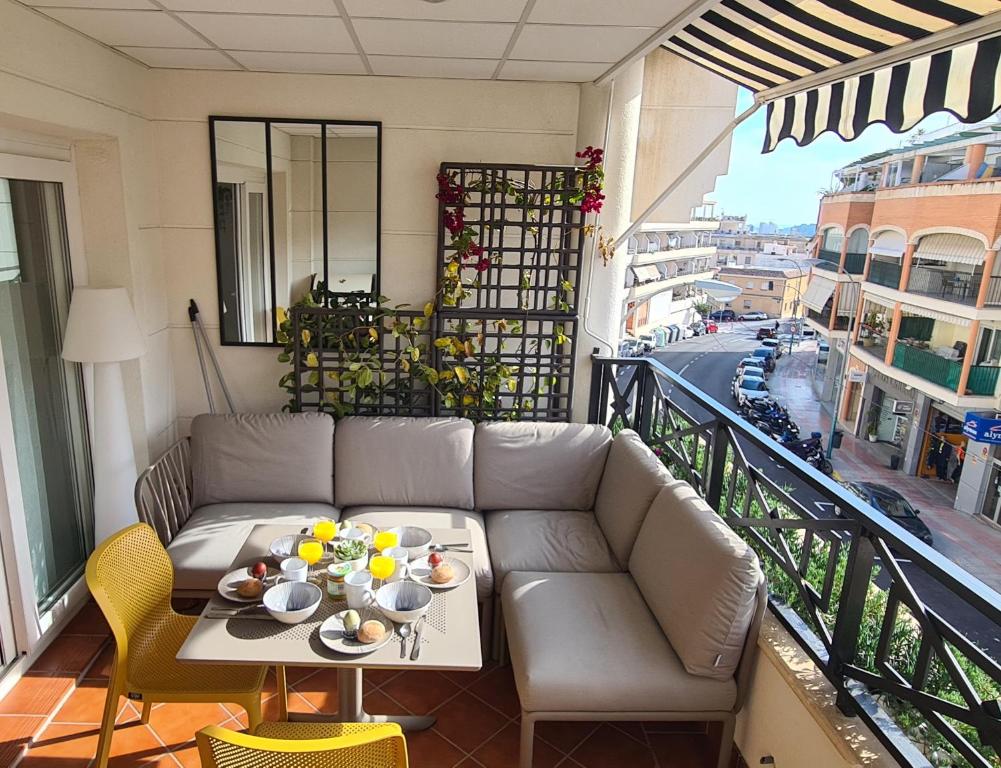 een woonkamer met een bank en een tafel op een balkon bij L'EsCALPE BAHIA - full wifi in Calpe