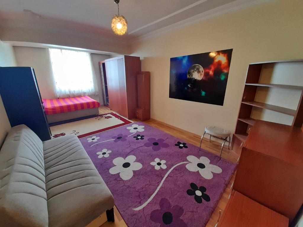 sala de estar con sofá y alfombra morada en Suit home and room in city center, en Erzurum