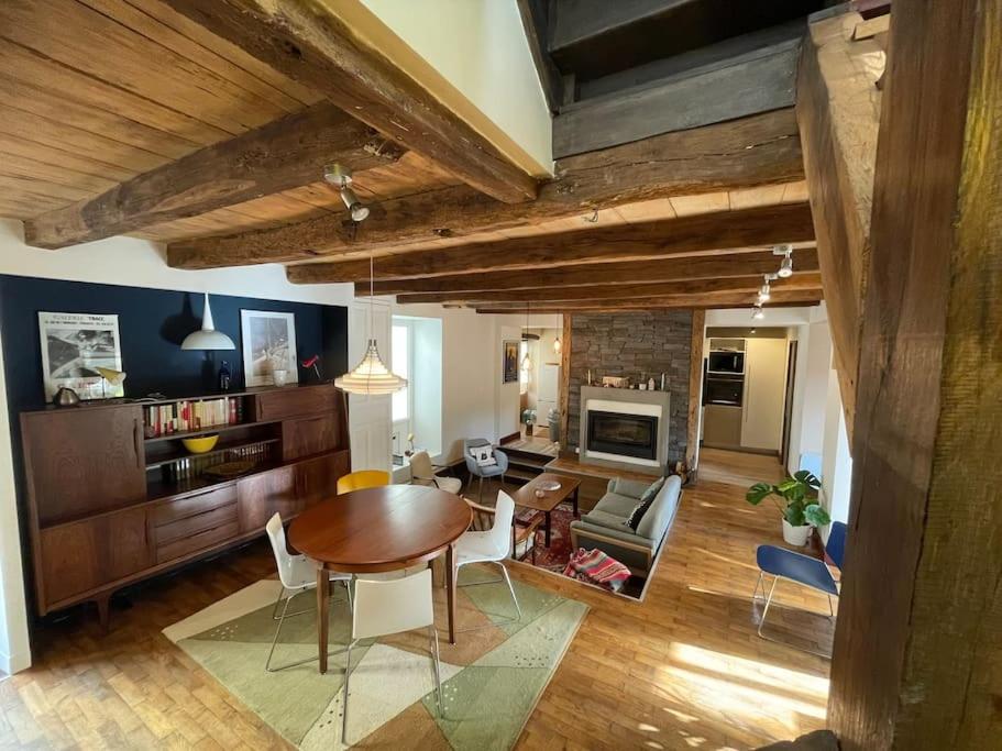 sala de estar con mesa de madera y comedor en Maison de charme proche Futuroscope, en Bonneuil-Matours
