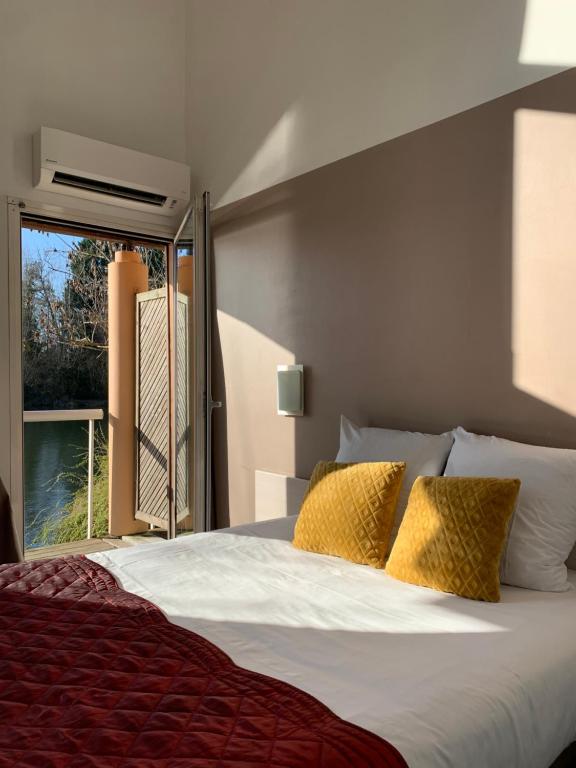 a bedroom with a large bed with a window at Hôtel L&#39;ile Du Saussay in Itteville