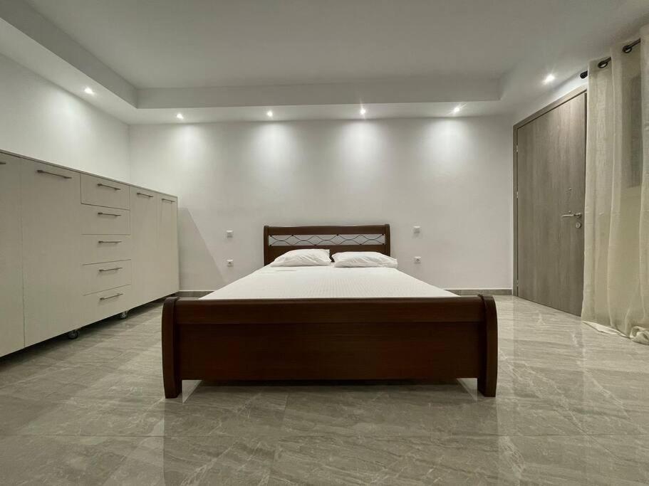 a bedroom with a bed and a white wall at EmilyApartments 1 in Chrysoupolis