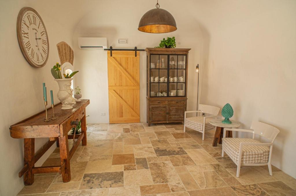 a room with a table and chairs and a clock on the wall at Masseria Il Passo in Favignana