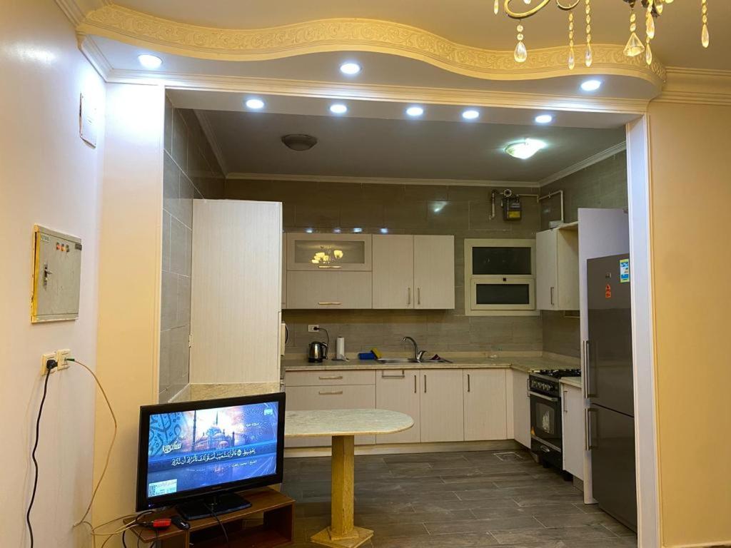 a kitchen with a table with a television on it at Heliopolis Residence Shrouk city Cairo in Madīnat ash Shurūq