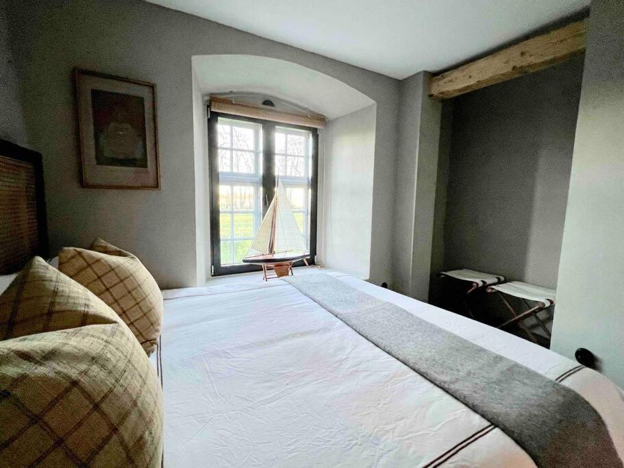 duże łóżko w pokoju z oknem w obiekcie Castle Apartment in Österlen - The Thott Suite w mieście Tomelilla