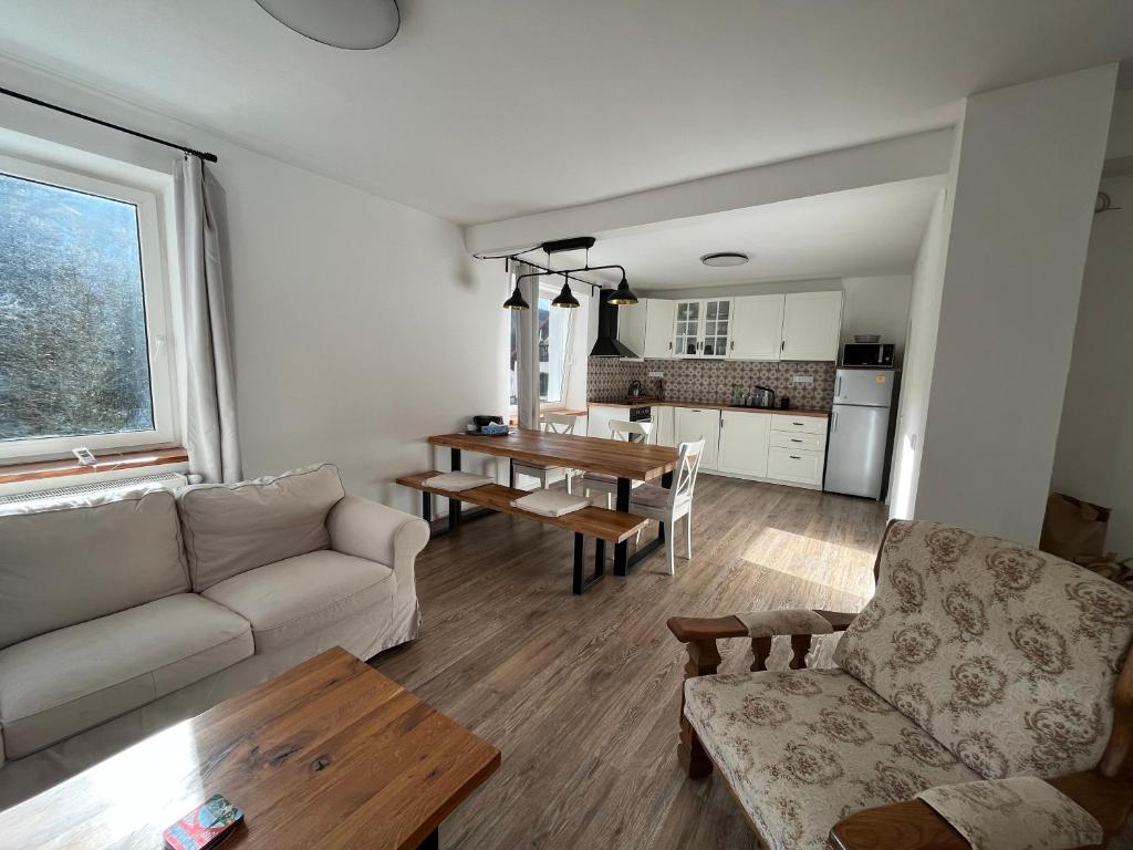 een woonkamer met een bank en een tafel bij Apartmány Josefáč se saunou, zahradou a dětským hřištěm in Josefuv dul