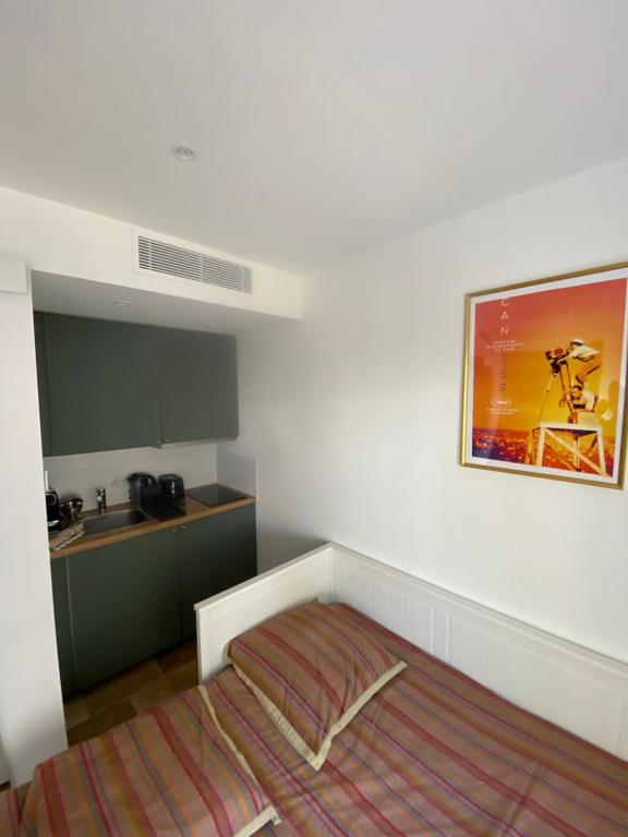 Cette petite chambre comprend un lit et une cuisine. dans l'établissement U Caseddu Cannes, à Cannes