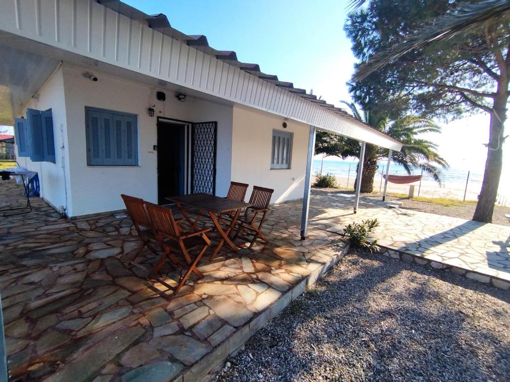 une terrasse avec des chaises et une table en face d'une maison dans l'établissement a front beach cottage in a protected area, à Mesolongion