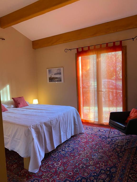 a bedroom with a large bed and a window at La Peyreyre in Jaujac