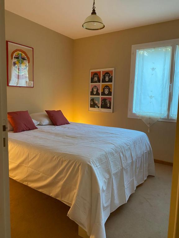 a bedroom with a white bed with a window at La Peyreyre in Jaujac