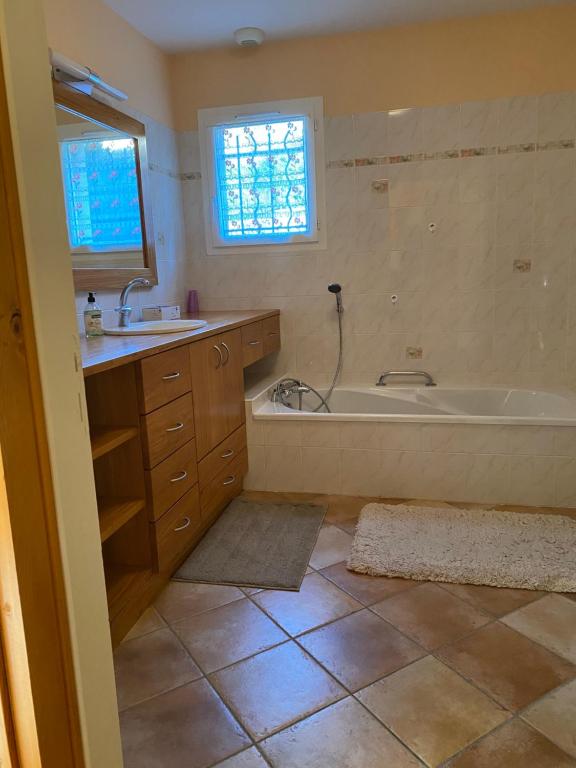a bathroom with a bath tub and a sink at La Peyreyre in Jaujac