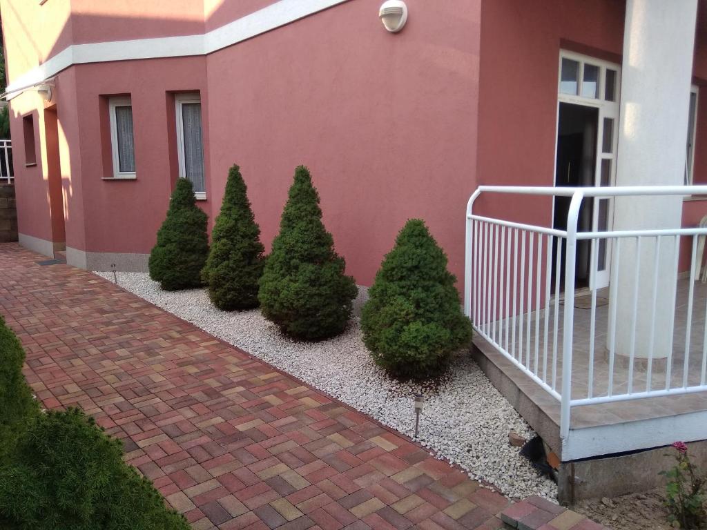 a row of christmas trees in front of a house at Panoráma apartman in Pécs