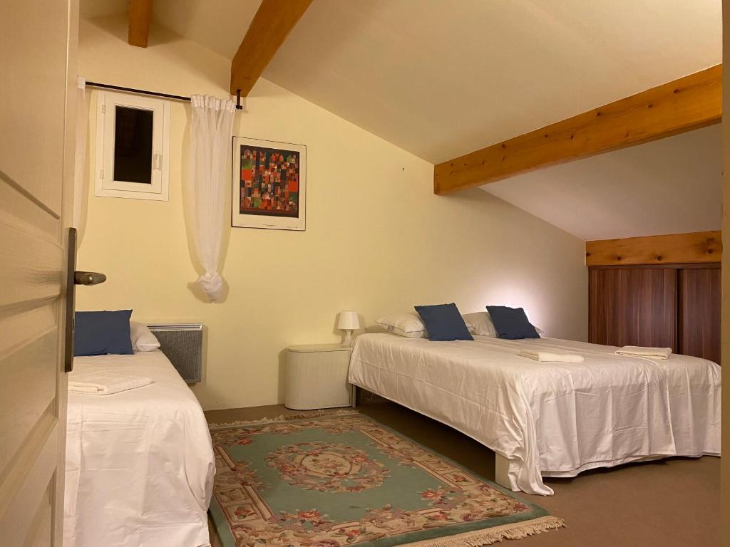 a bedroom with two beds and a rug at La Peyreyre in Jaujac