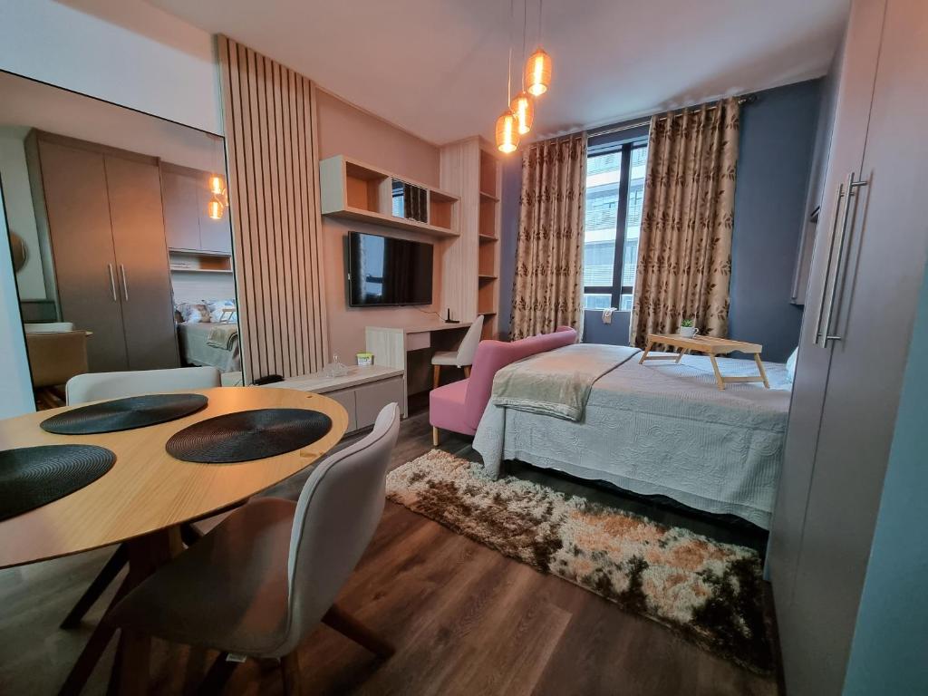 um quarto com uma cama, uma mesa e cadeiras em Flat luxo, mobiliado c/ ar, wi-fi, pisc. e academia em Barueri