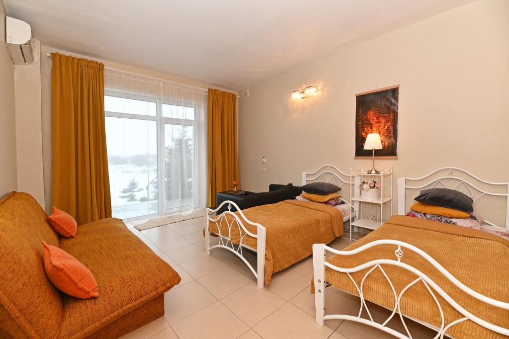 a living room with two beds and a couch at MS Resort in Nemėžis