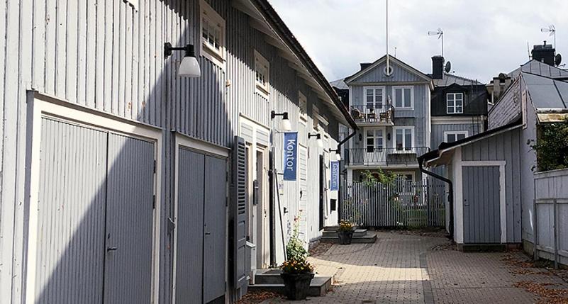 eine Reihe weißer Gebäude neben einem Zaun in der Unterkunft Sjögården in Vadstena