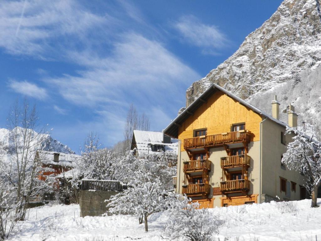 a building with a balcony in the snow at Chalet les Alpes - Le Sapey in Vénosc