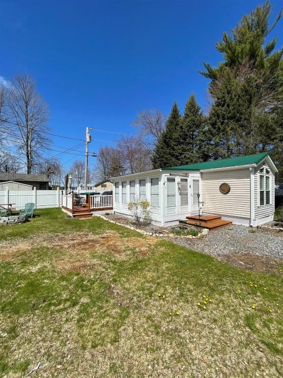 a white house with a green roof in a yard at SUNNY BREAK- LIMIT 6 cottage in Raymond