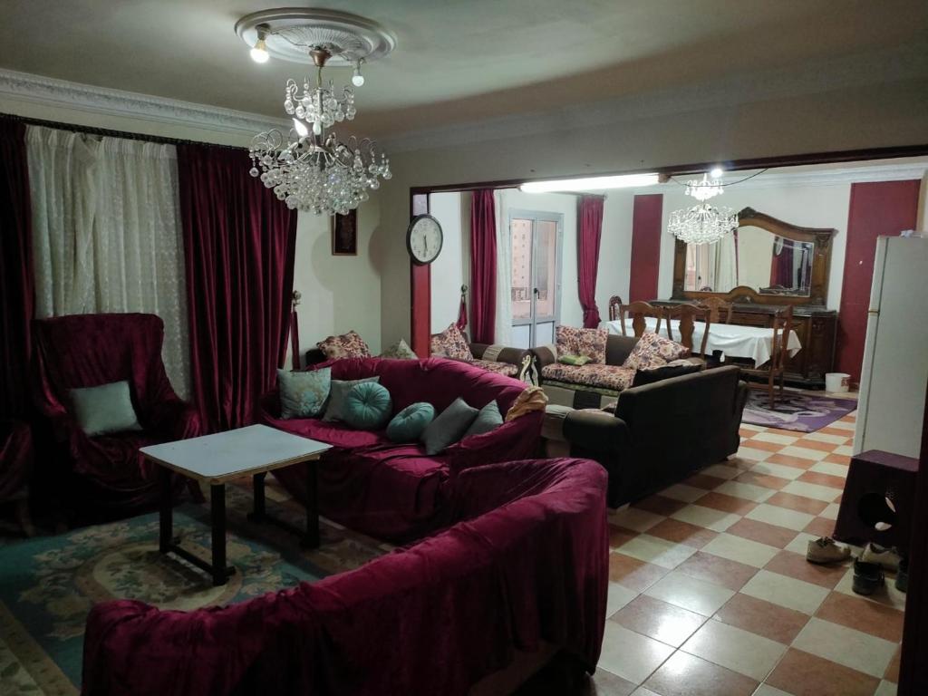 a living room with purple couches and a chandelier at غير متاحه للايجار الرجاء عدم الحجز لانها غير متوفره in Alexandria