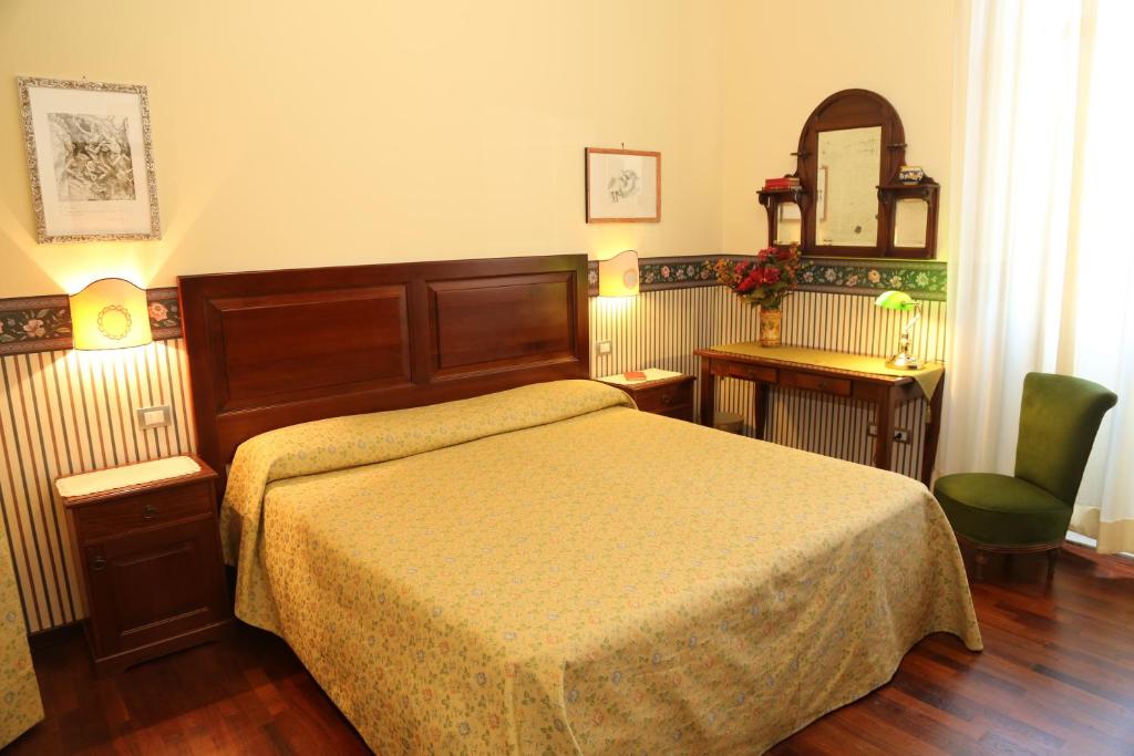 1 dormitorio con cama, silla y espejo en B&B La Vetreria Almarù, en Catania