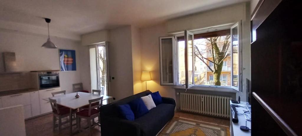 een woonkamer met een bank, een tafel en een raam bij Carachouse-Parma in Parma