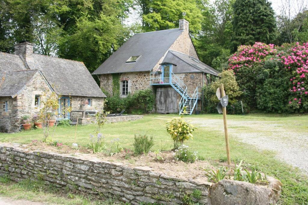 una antigua casa de piedra con un jardín delante de ella en Home Kervezec, en Garlan