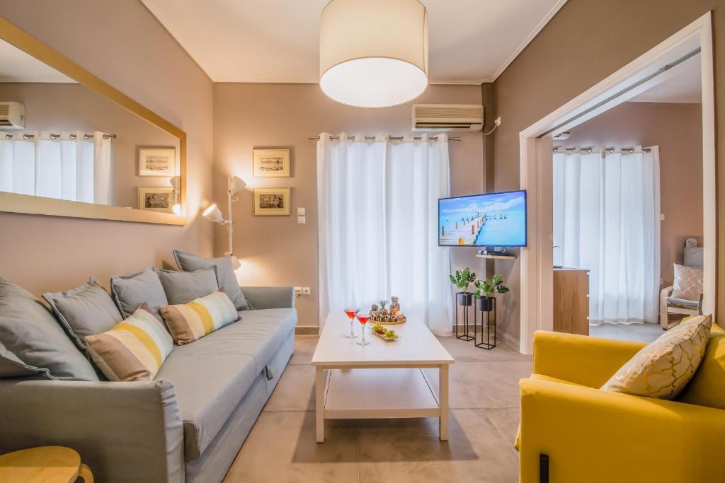 sala de estar con sofá y TV en Glyfada's Central Apartment, en Atenas